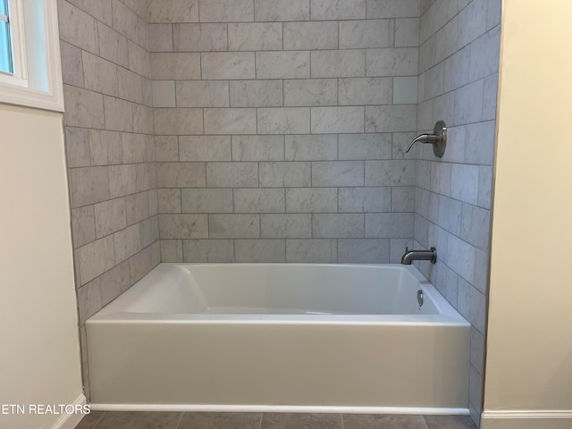 bathroom with tile patterned flooring and bathtub / shower combination