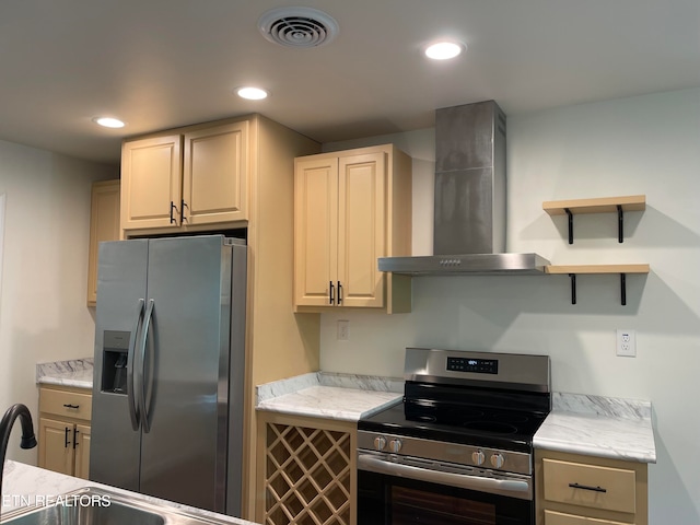 kitchen with stainless steel appliances and wall chimney range hood