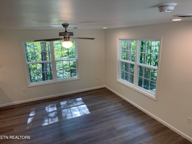 empty room with ceiling fan and dark wood-type flooring