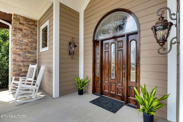 view of exterior entry featuring covered porch