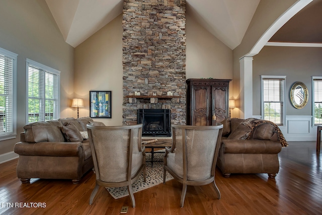 living room with a fireplace, dark wood-type flooring, high vaulted ceiling, and plenty of natural light