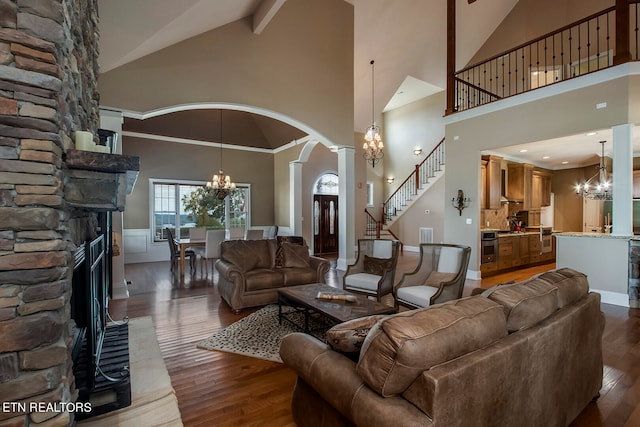 living room with a fireplace, high vaulted ceiling, ornamental molding, a chandelier, and dark wood-type flooring