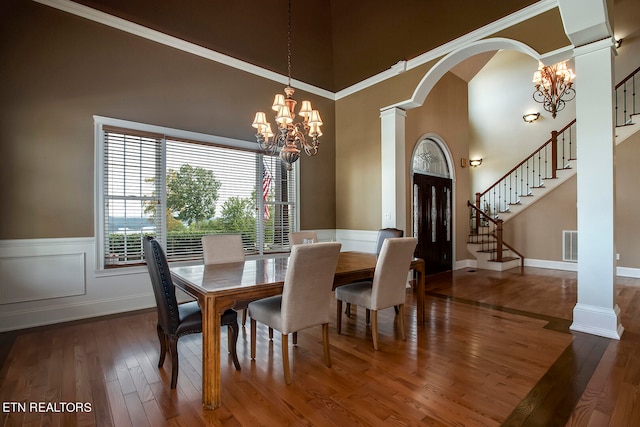 dining room featuring ornamental molding, dark hardwood / wood-style flooring, a chandelier, and a high ceiling