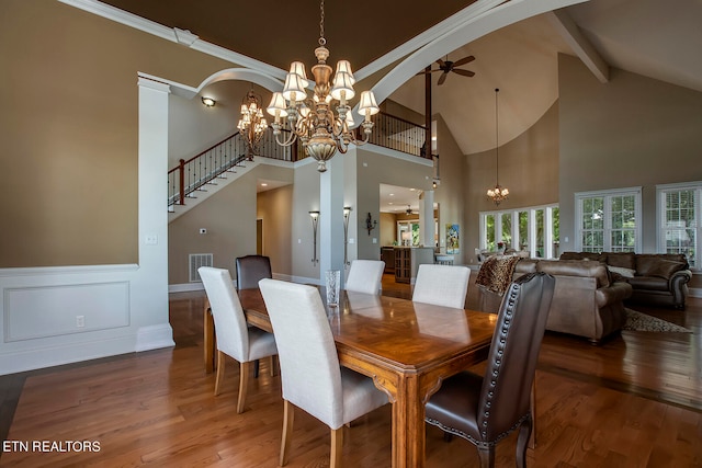 dining area featuring ceiling fan with notable chandelier, high vaulted ceiling, and wood-type flooring