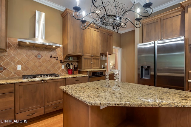 kitchen featuring light wood-type flooring, light stone counters, stainless steel appliances, and wall chimney exhaust hood