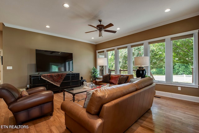 living room featuring ceiling fan, ornamental molding, and light hardwood / wood-style floors