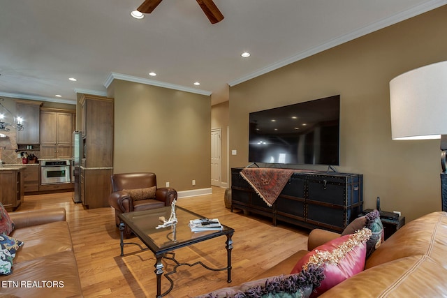 living room with ceiling fan, ornamental molding, and light wood-type flooring