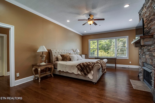 bedroom with a fireplace, a textured ceiling, dark hardwood / wood-style floors, ceiling fan, and ornamental molding