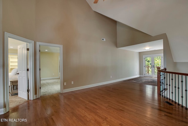 interior space with high vaulted ceiling, wood-type flooring, and french doors