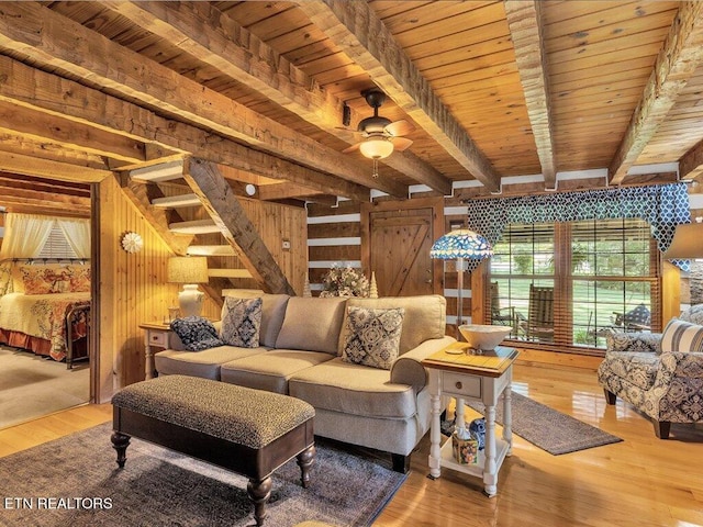 living room featuring wood walls, beamed ceiling, wooden ceiling, hardwood / wood-style floors, and ceiling fan