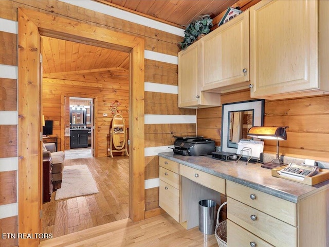 kitchen featuring light wood-type flooring, built in desk, light brown cabinets, and lofted ceiling