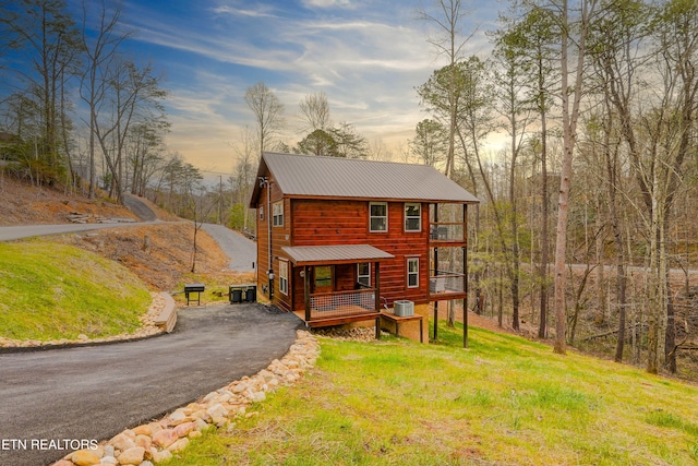 view of front of house with central AC and a yard