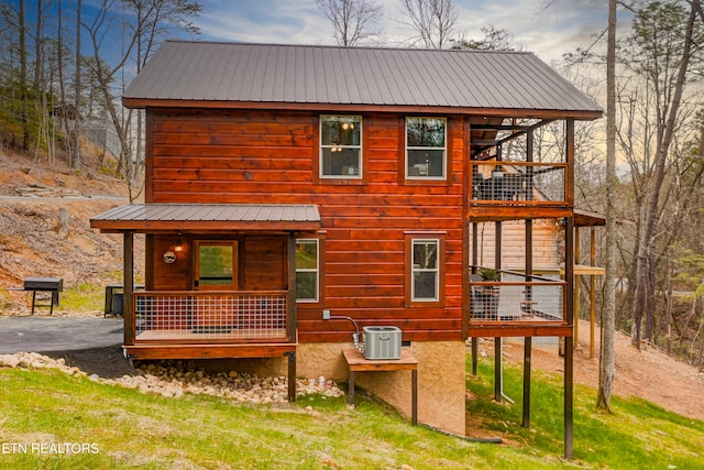 view of front of home featuring a balcony and central AC unit