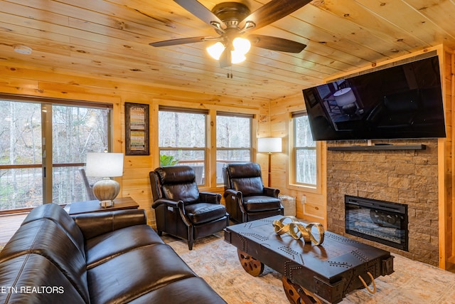 living room with a wealth of natural light, ceiling fan, and wooden walls