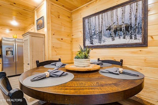 dining room with wooden ceiling, hardwood / wood-style floors, and wood walls