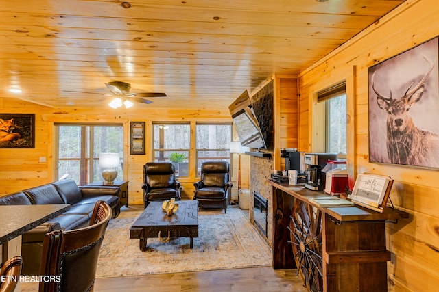 living room featuring wood ceiling, hardwood / wood-style floors, wood walls, and ceiling fan