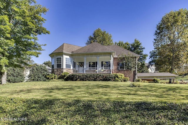 view of front of house with covered porch, stone siding, and a front yard