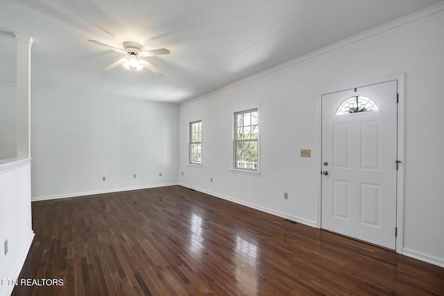 foyer entrance featuring visible vents, baseboards, ceiling fan, wood finished floors, and ornate columns