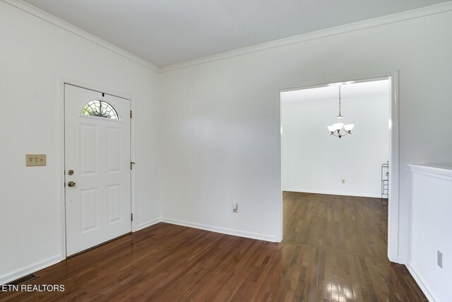 entrance foyer featuring crown molding, an inviting chandelier, and dark hardwood / wood-style floors