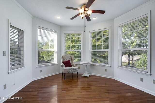 sitting room with crown molding, dark wood-type flooring, and ceiling fan