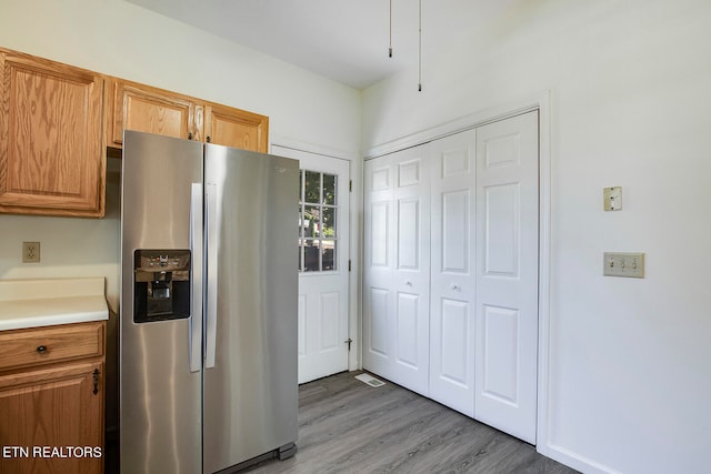 kitchen with stainless steel refrigerator with ice dispenser and hardwood / wood-style floors