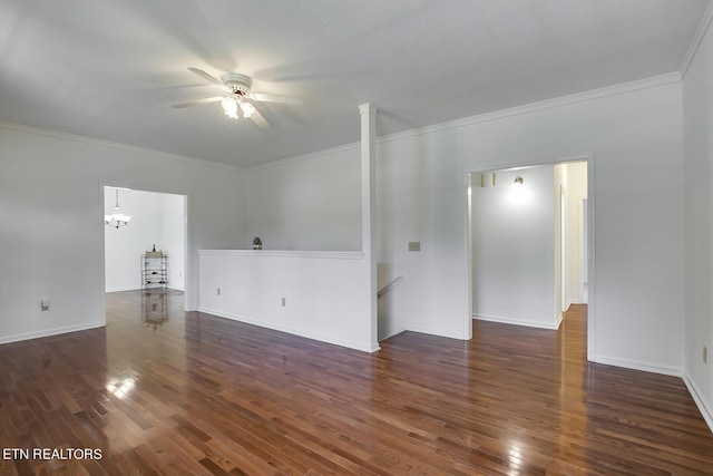 empty room featuring ceiling fan with notable chandelier, crown molding, baseboards, and wood finished floors