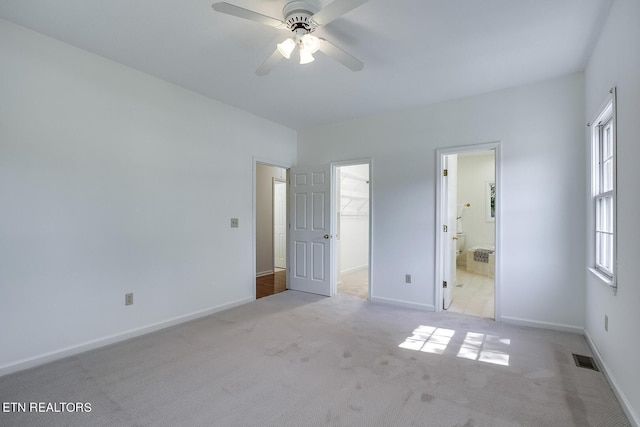 unfurnished bedroom featuring carpet floors, baseboards, a spacious closet, and visible vents