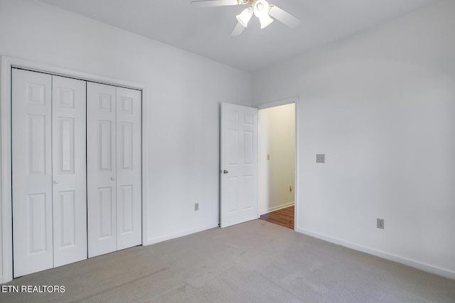 unfurnished bedroom with carpet, baseboards, ceiling fan, and a closet