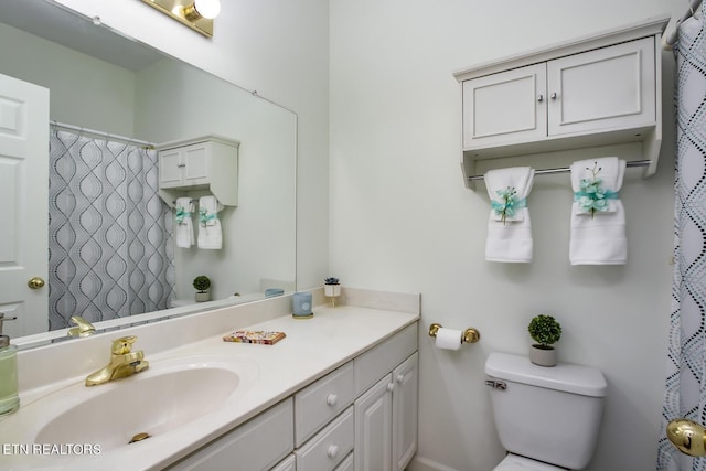 bathroom featuring toilet, a shower with shower curtain, and vanity