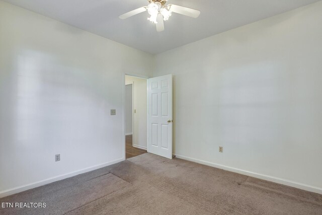 carpeted spare room featuring ceiling fan