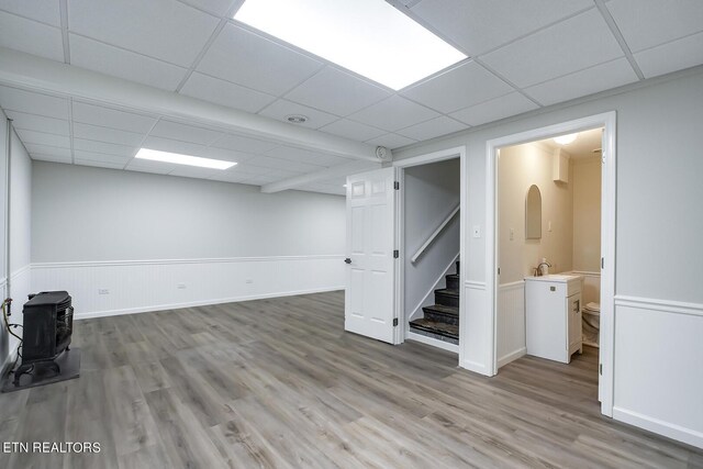 basement featuring hardwood / wood-style flooring and a drop ceiling