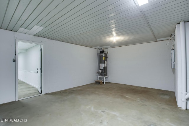 garage featuring concrete block wall and water heater