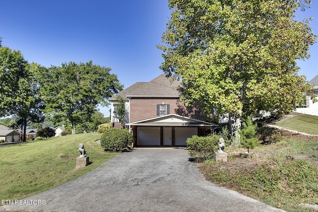 traditional-style house with a garage, driveway, and a front lawn