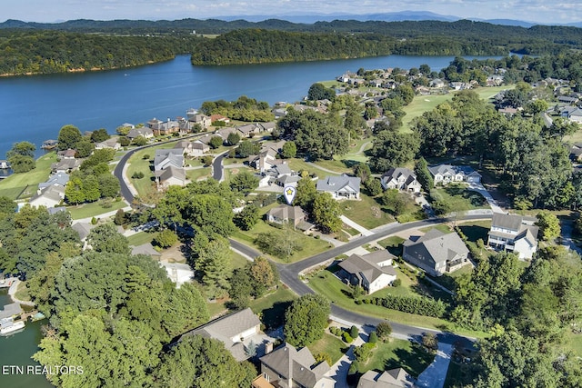 birds eye view of property featuring a water view, a residential view, and a view of trees