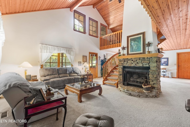 living room with high vaulted ceiling, carpet flooring, a stone fireplace, wood ceiling, and beam ceiling