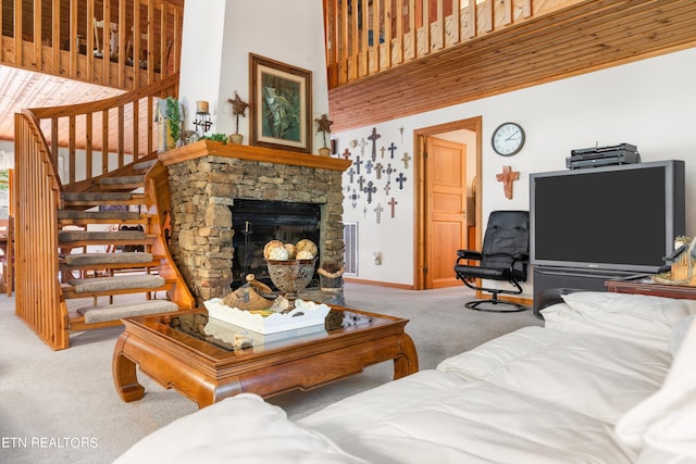 carpeted living room with a towering ceiling and a fireplace