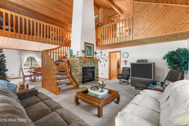 carpeted living room with high vaulted ceiling, wooden ceiling, and a stone fireplace