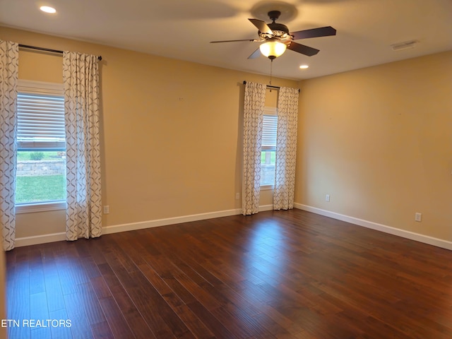 spare room with a ceiling fan, recessed lighting, dark wood finished floors, and baseboards