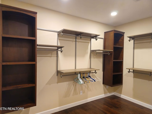 spacious closet with dark hardwood / wood-style flooring