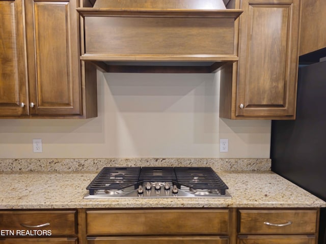 kitchen with stainless steel gas cooktop and light stone countertops