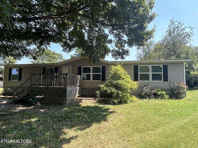 manufactured / mobile home with a wooden deck and a front yard