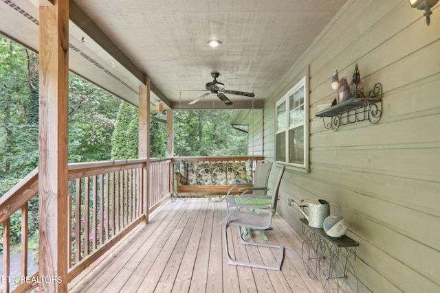 wooden deck with a porch and ceiling fan