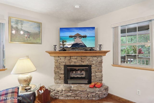 living room with a fireplace, a textured ceiling, and hardwood / wood-style flooring