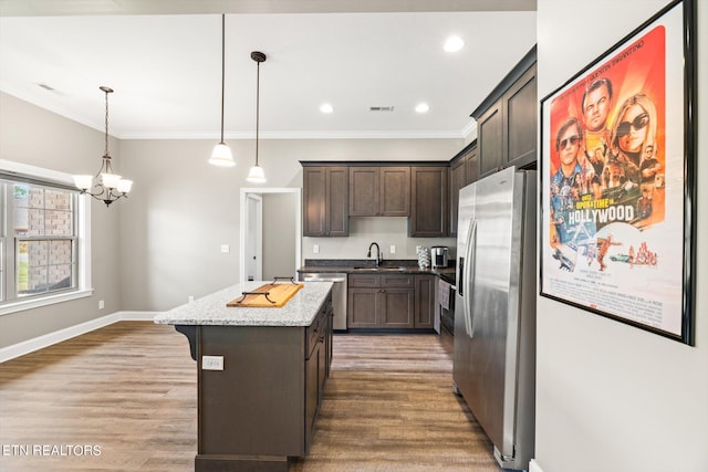 kitchen featuring appliances with stainless steel finishes, a center island, wood-type flooring, and sink