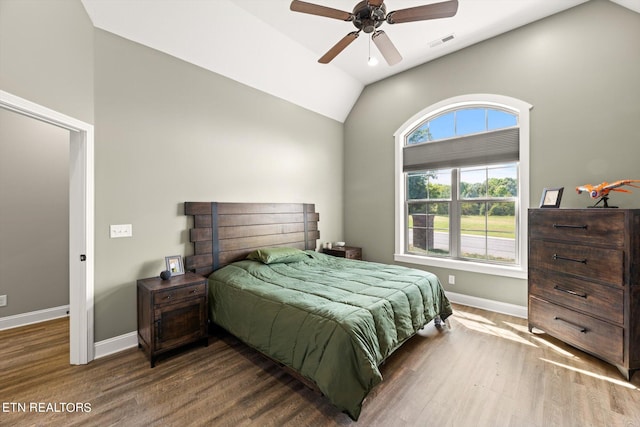 bedroom with ceiling fan, vaulted ceiling, and dark hardwood / wood-style flooring