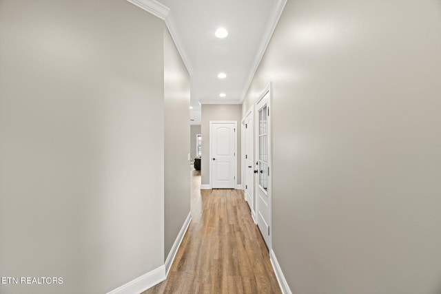 hallway with baseboards, ornamental molding, wood finished floors, and recessed lighting