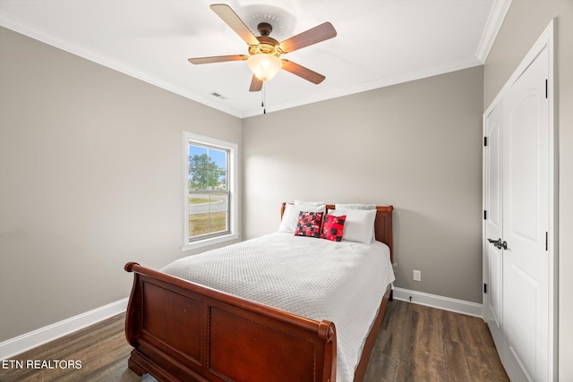 bedroom featuring dark wood-type flooring, ceiling fan, and ornamental molding