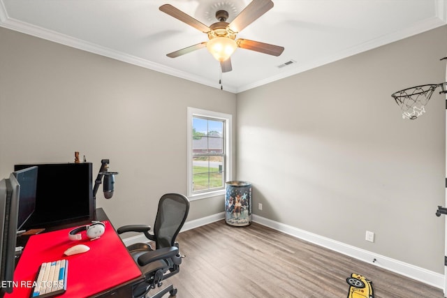 home office featuring wood finished floors, ornamental molding, ceiling fan, and visible vents