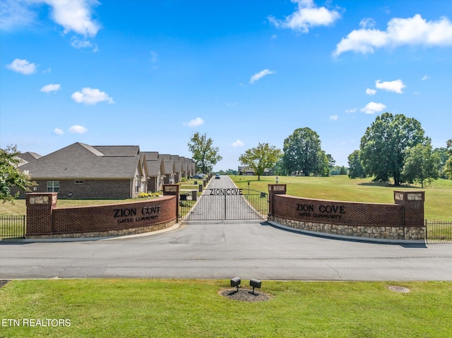 view of home's community with a gate, fence, and a lawn