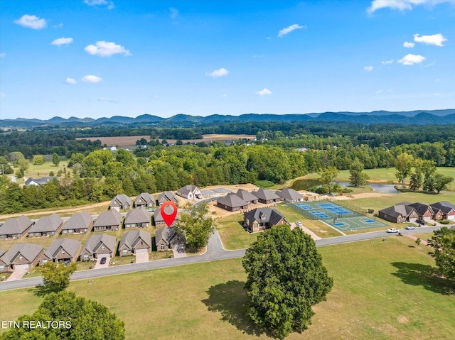 aerial view with a wooded view, a mountain view, and a residential view